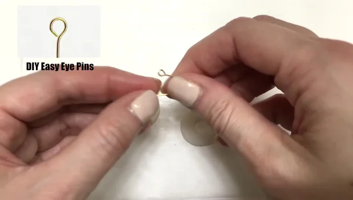 Insert eye pins into the holes, ensuring they are secured. For polymer clay, consider baking the pins beforehand or pre-making holes.
