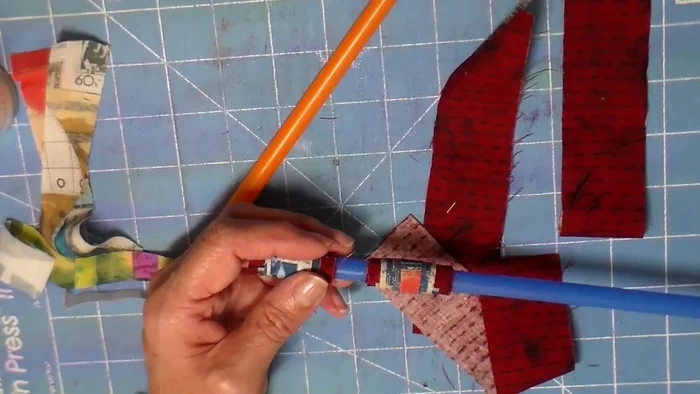 Add beads: Insert beads onto the straw. The narrator uses five beads, but mentions only getting four onto some straws.