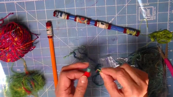 Decorate with cords and beads: String a bead onto a cord or fiber using a needle threader and tie it tightly around a bead on the straw, creating a focal point.