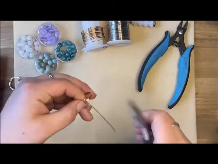 Secure the ring band: Using chain nose pliers, create a 90-degree angle, then another 90-degree angle to wrap the excess wire around the ring band three times.