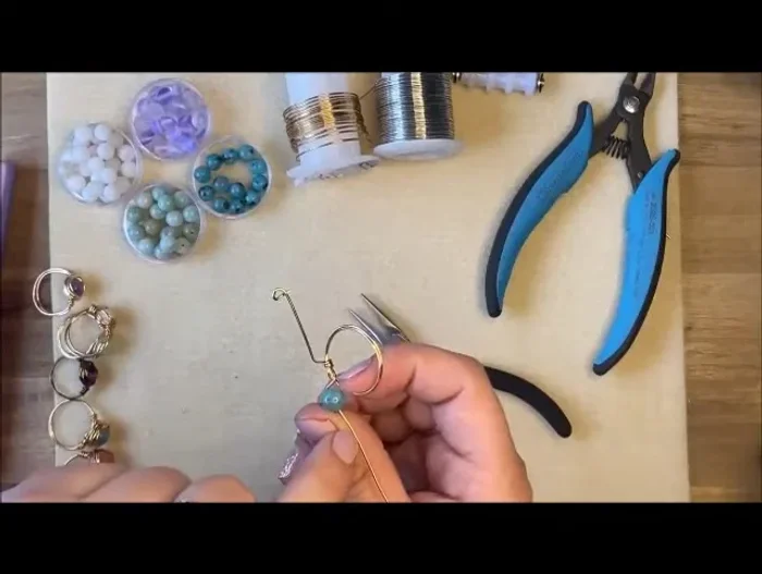 Secure the gemstone: Create another 90-degree angle on the opposite side of the ring band, wrapping the wire underneath and back to the starting point. Slide the ring back onto the mandrel.