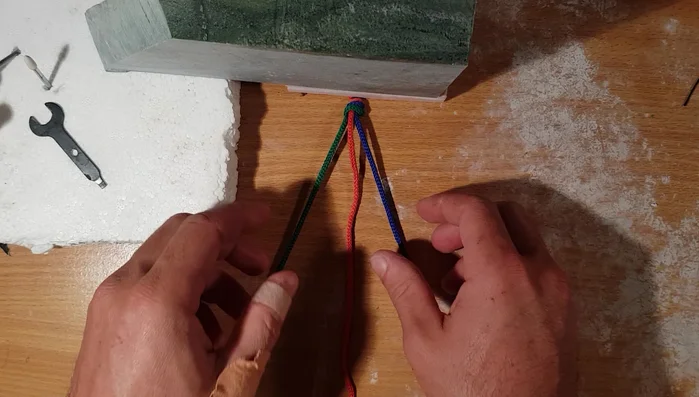 Take the leftmost strand and cross it over the new middle strand, making it the new middle strand.