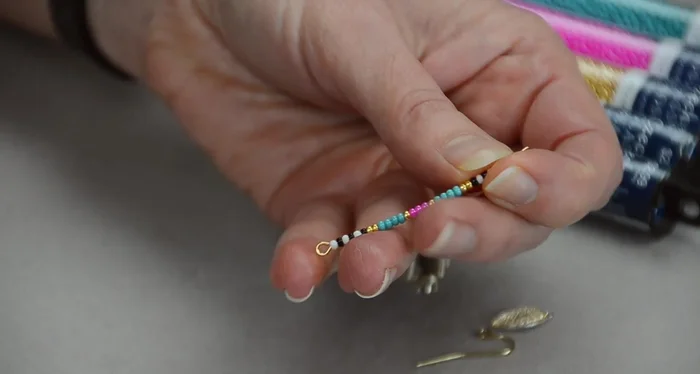Create the top loop: Use chain nose pliers to bend the eye pin 90 degrees above the last bead. Then, use round nose pliers to form a loop, matching the size of the loop at the bottom of the eye pin.