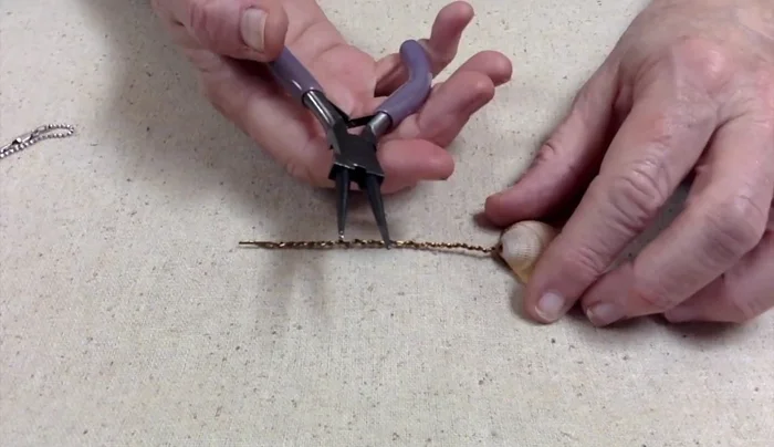 Wrap the wire around the loop, creating the bail. Wrap it multiple times for a more secure and organic look.