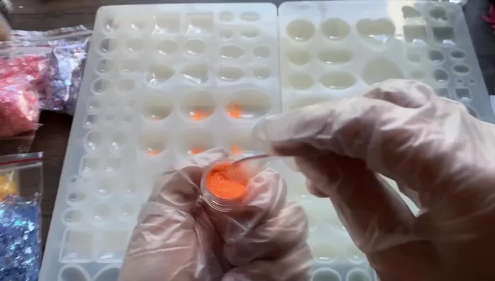 Add orange glitter to molds. Don't overfill.