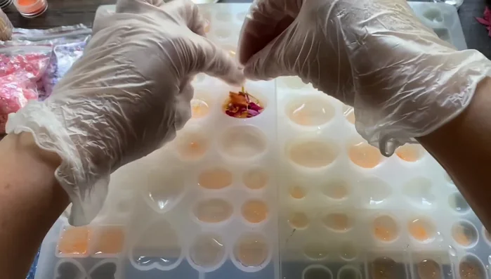 Add yellow glitter flakes on top of the orange glitter and resin layer. This adds shimmer.