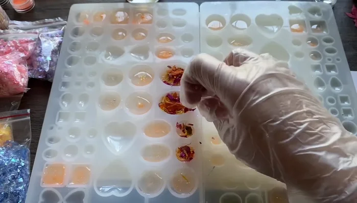 Add yellow glitter flakes on top of the orange glitter and resin layer. This adds shimmer.