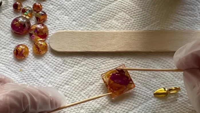 For the smaller, flatter pieces, apply UV resin to the back and attach flat back brad hooks. Cure with UV light for 30 seconds.