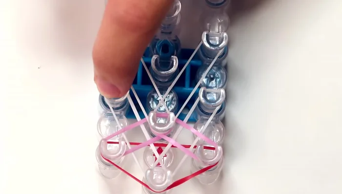 Repeat pattern until end of loom: Continue the pattern of white diagonal bands followed by colored bands until you reach the second to last pins on the left and right rows.