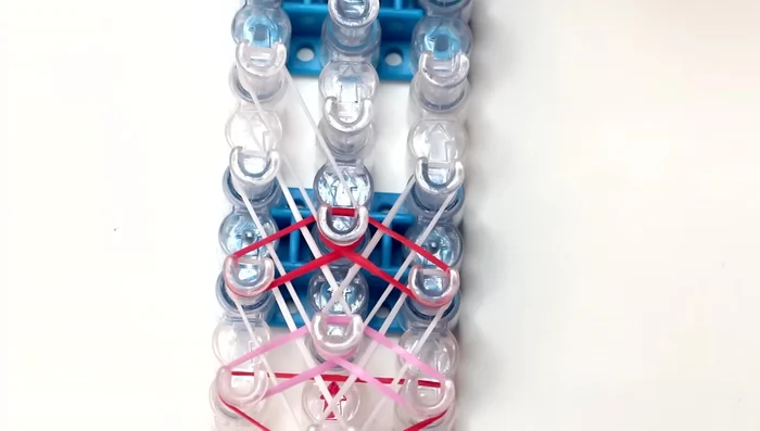 Repeat pattern until end of loom: Continue the pattern of white diagonal bands followed by colored bands until you reach the second to last pins on the left and right rows.