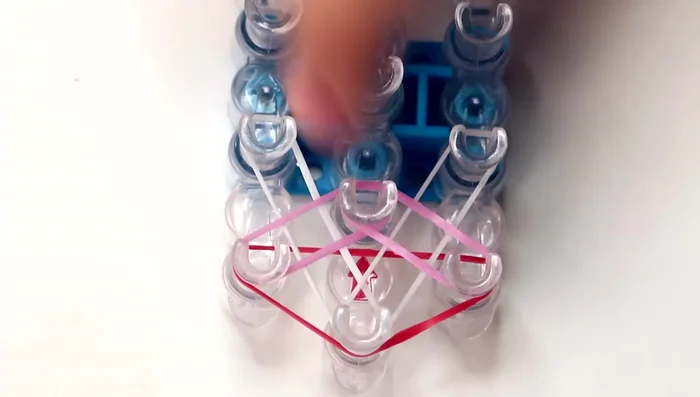 Repeat pattern until end of loom: Continue the pattern of white diagonal bands followed by colored bands until you reach the second to last pins on the left and right rows.