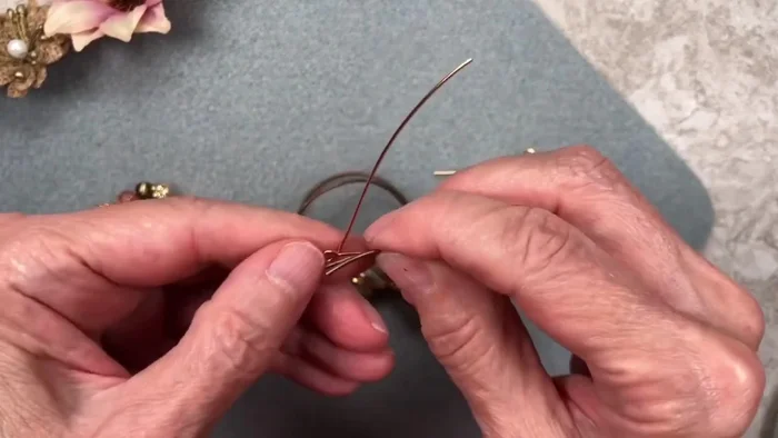 Wrap the wire around the cord ends and loops, securing with pliers. Make about 5 tight wraps.