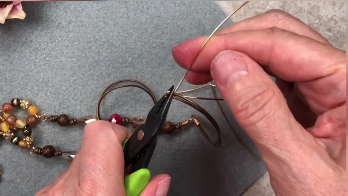 Wrap the wire around the cord ends and loops, securing with pliers. Make about 5 tight wraps.