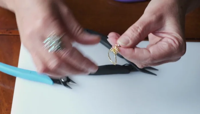 Add beads to each loop, ensuring the loops are securely closed after each bead is added.