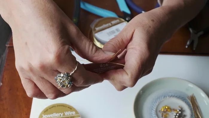 Use flat nose pliers to make a 90-degree bend at the ends of the wires, pushing them down towards the tube and bringing the ends up.