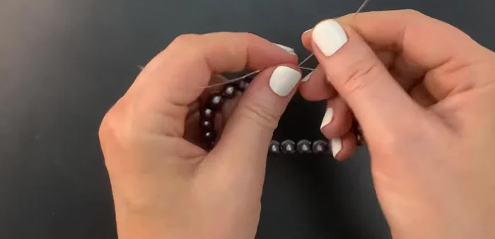 Lay the right side cord on top of the left, and bring it around the left side, making two full loops.