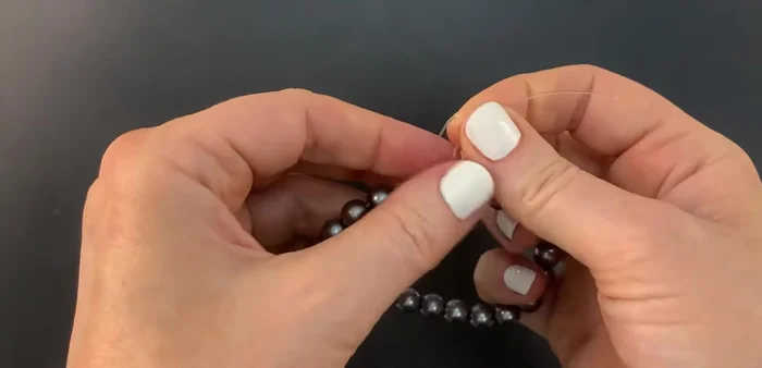 Lay the right side cord on top of the left, and bring it around the left side, making two full loops.