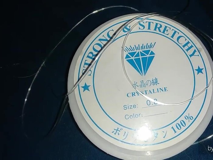 Secure the cord: Tape one end of the stretchy cord to a surface to prevent beads from rolling away.