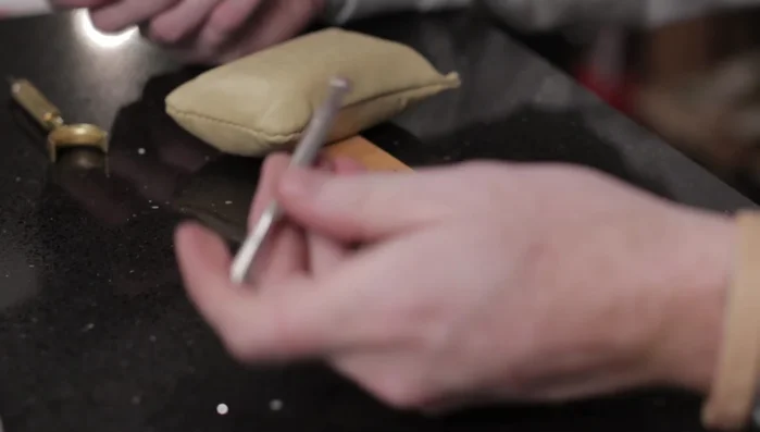 Bevel the edges using a Barry King check beveler (number two). Start on the main stem and work your way out, applying heavier pressure at the end of the line and lighter pressure at the beginning. Ensure the leather is not too wet.