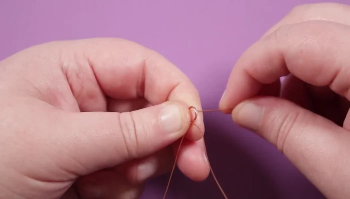 Wrap the long end of the copper wire around the circles, creating a secure base. Create alternating short (4mm) and long (7mm) spikes by measuring from the base circles and wrapping the wire around and through the circles.