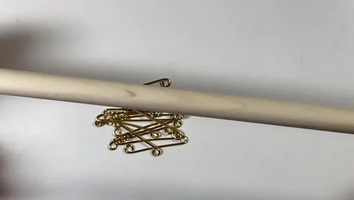 Wrap links around dowel to form horseshoe shapes, ensuring loops are flat against the dowel. Use pliers to adjust and create a rounded shape.