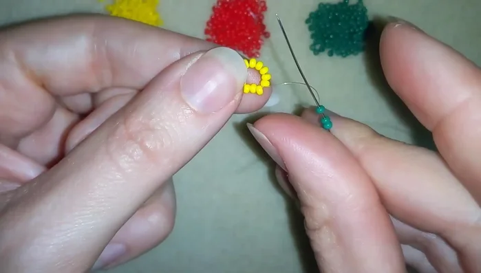Add 2 red beads, go through the green and yellow beads in a circle.