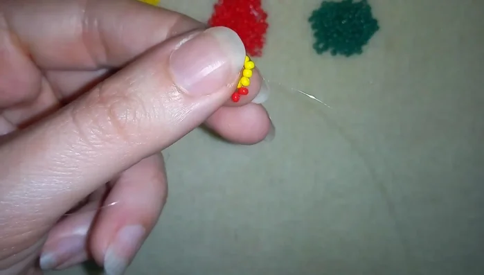Complete the flower by adding beads following the pattern until the end of the row. Then add 3 yellow beads and return to the starting green bead.