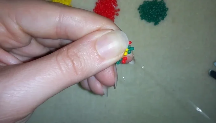 Complete the flower by adding beads following the pattern until the end of the row. Then add 3 yellow beads and return to the starting green bead.