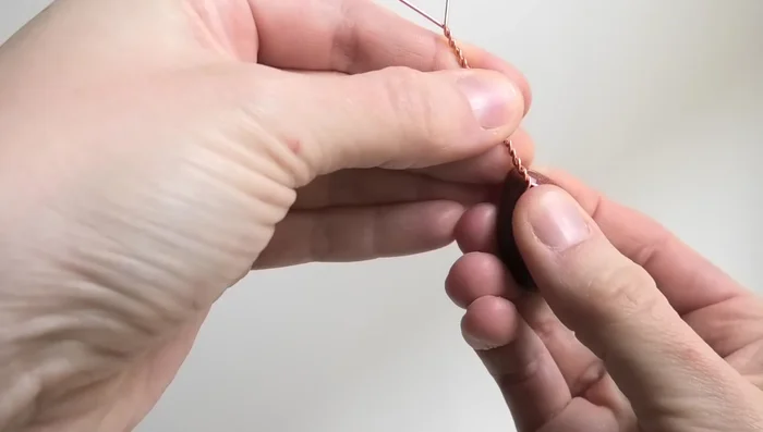 Continue twisting until the wire reaches almost to the bottom of the cabochon.