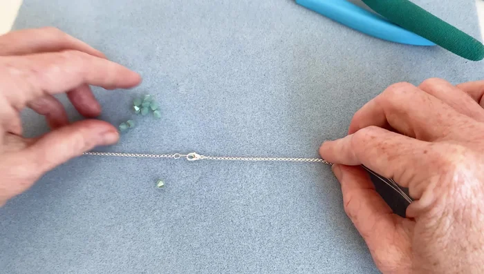 Cut the necklace at the determined points, leaving the clasp in the center.