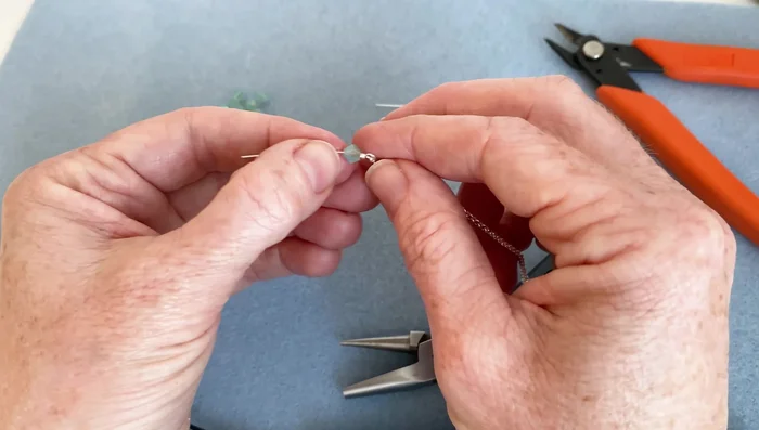 Add the focal bead: Attach your chosen bead(s) to the head pin above the loop.