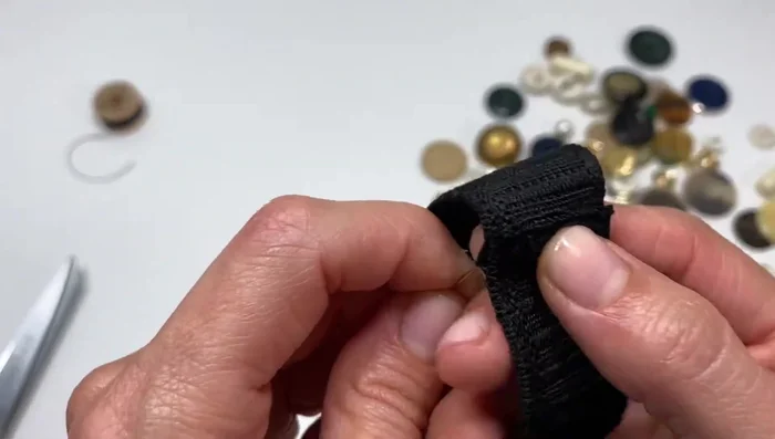 Begin sewing the buttons onto the elastic using a double-threaded needle and button thread (for added strength and less need for multiple stitches per button). Secure each button with several stitches, creating an X or straight lines depending on preference.