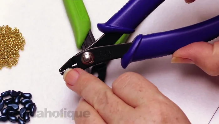 Crimp the tube using crimping pliers to create a secure V-shape. Repeat the crimping process to fully secure the clasp.