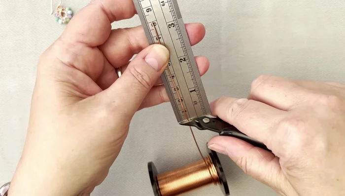 Using the first step of the pliers, create a small kink in the wire to prepare for the next loop.