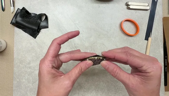 Attach the back piece, ensuring the pin is securely fastened.