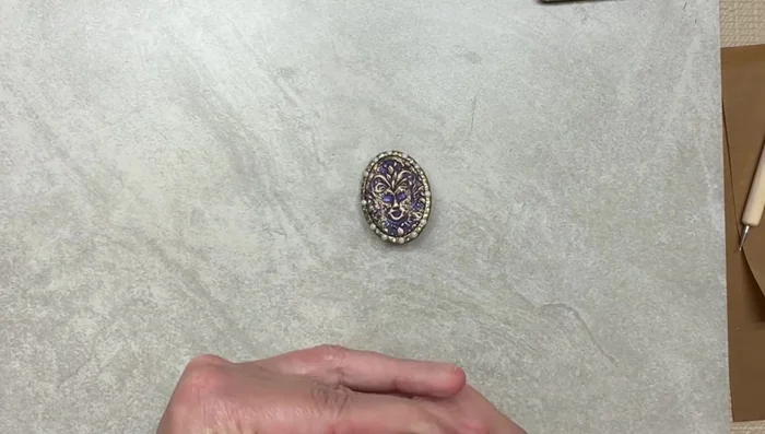 Apply Sculpey gloss glaze to the back of the brooch, wiping off any excess on the stones.