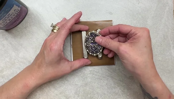 Apply resin to the front of the brooch, using a tool to spread evenly and remove bubbles.