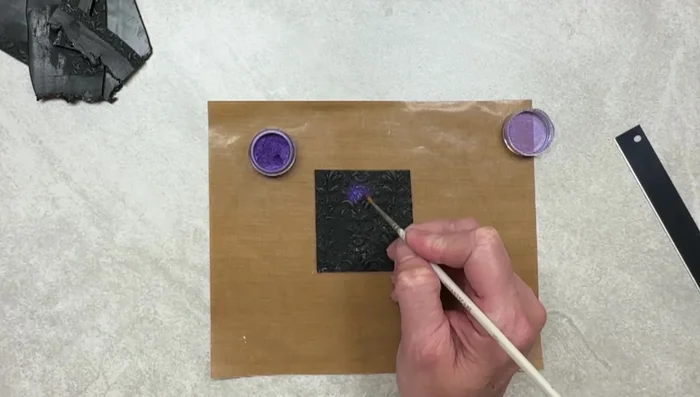 Gently brush away excess purple M powder.