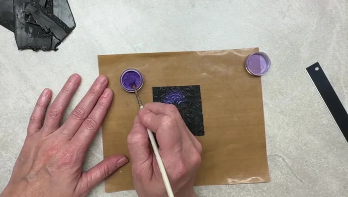 Gently brush away excess purple M powder.