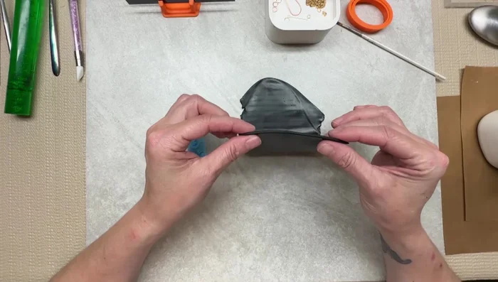 Roll out black polymer clay to a desired thickness (around number 2 on a pasta machine).