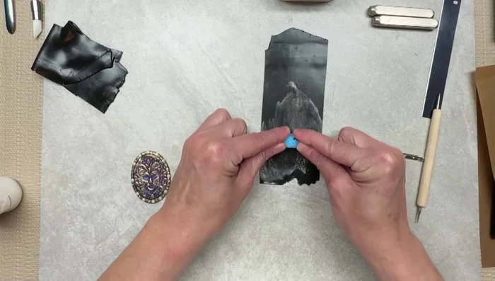 Apply gold M powder to the back of the brooch, blending edges for a seamless finish.