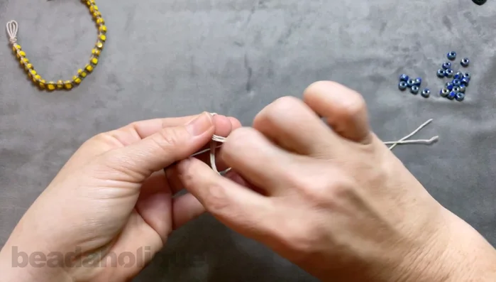 Tie another overhand knot to secure the first one. Trim the excess cord, leaving about an inch.