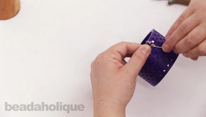 Loop the wire around one of the pegs on the jig, keeping it tight. Bend the wire up and over the top peg, then down and around the second peg.