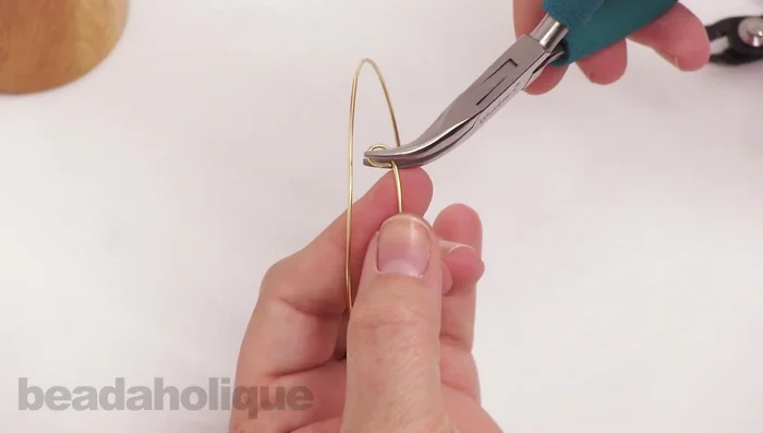 Use bent chain nose pliers to refine the bangle's shape, creating sharper angles at the ends.