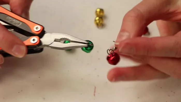 Attach subsequent jingle bells to the existing ones by looping an O-ring through the previous jingle bell's loop and attaching the next jingle bell to it. Close the O-ring securely.