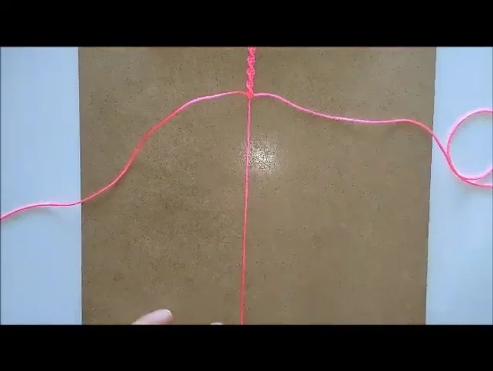 Add the first bead after completing the first third of the spiral. Secure it with square knots (over, over, under, under, through).