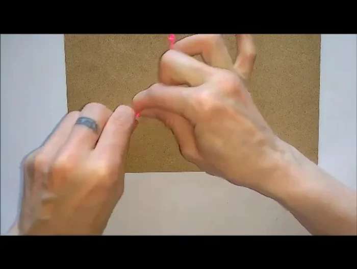 Tie a knot at the end, pull tight, and repeat on the other side. Trim excess and seal with a lighter or glue.