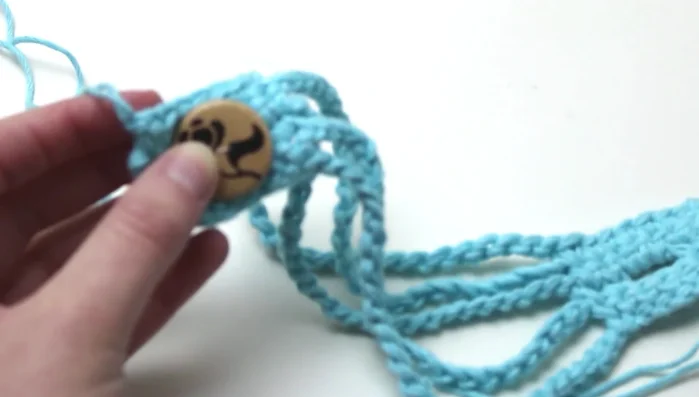 Sew on the button to the side without the buttonhole.