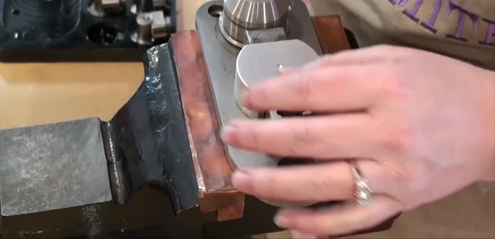 Shape the earring further using the round peg, ensuring the wire is properly aligned before tightening.