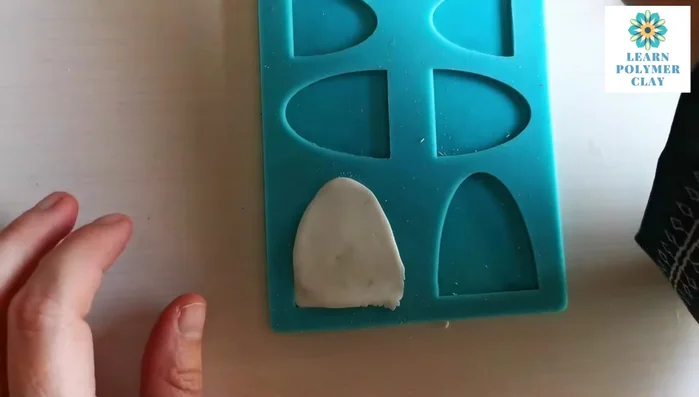 Carefully remove excess clay using a sharp blade, cutting parallel to the mold.